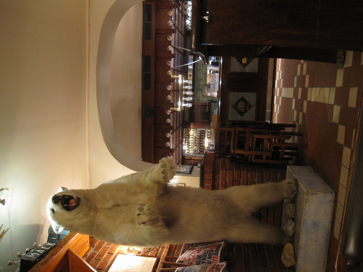 Historic Ølhallen interior with a taxidermied polar bear beside the bar
