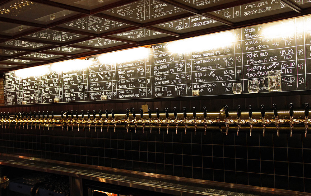 The long row of beer taps and chalkboard inside Ølhallen in Tromsø
