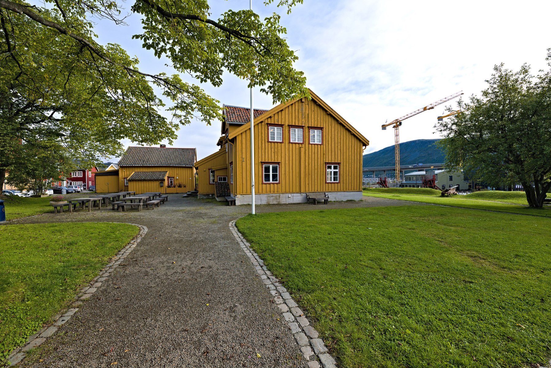 Yellow wooden customs house on the grassy Skansen mound in Tromsø