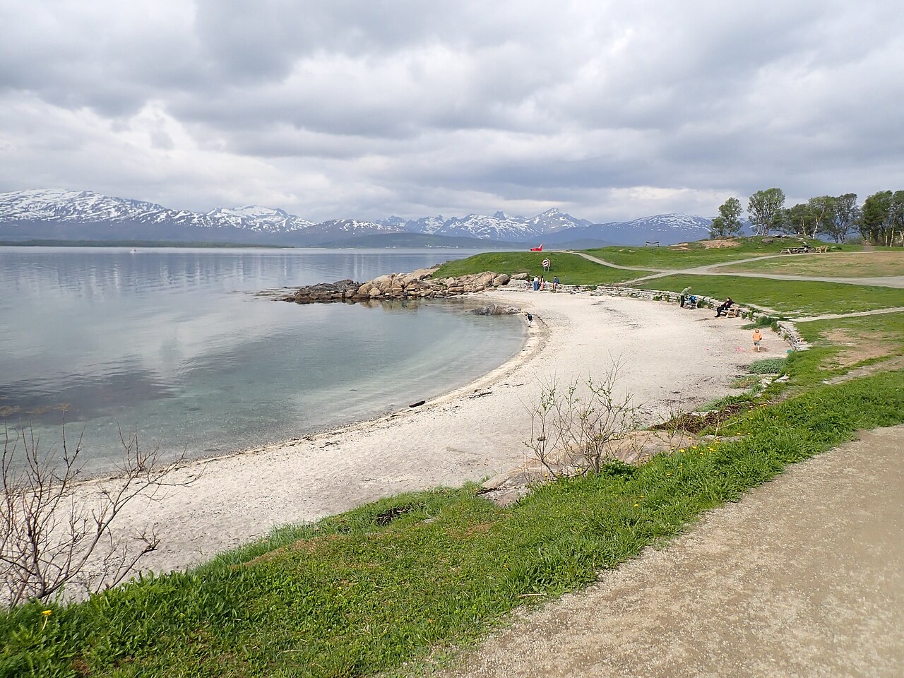 The sandy beach at Telegrafbukta with water and snow-topped mountains beyond