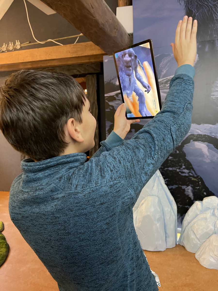 A child viewing a digital troll through a tablet at the museum in 2021