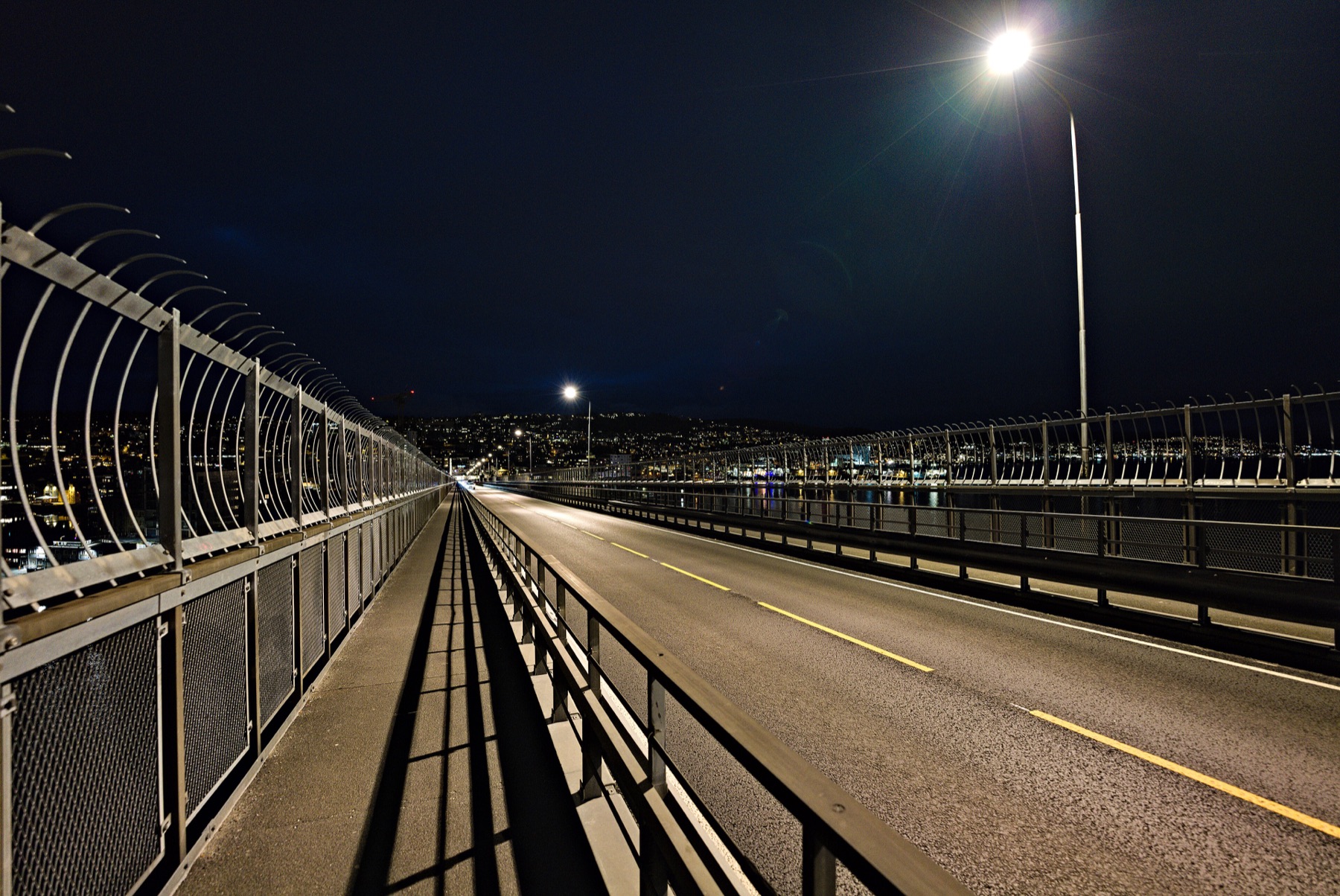 The pedestrian path and roadway on Tromsø Bridge at night