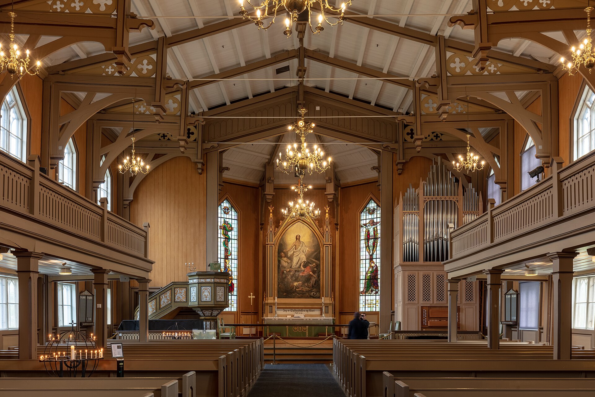 Wooden beams, pews, stained glass and altar inside Tromsø Cathedral