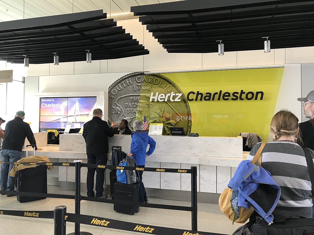 Travellers at a Hertz airport car rental counter