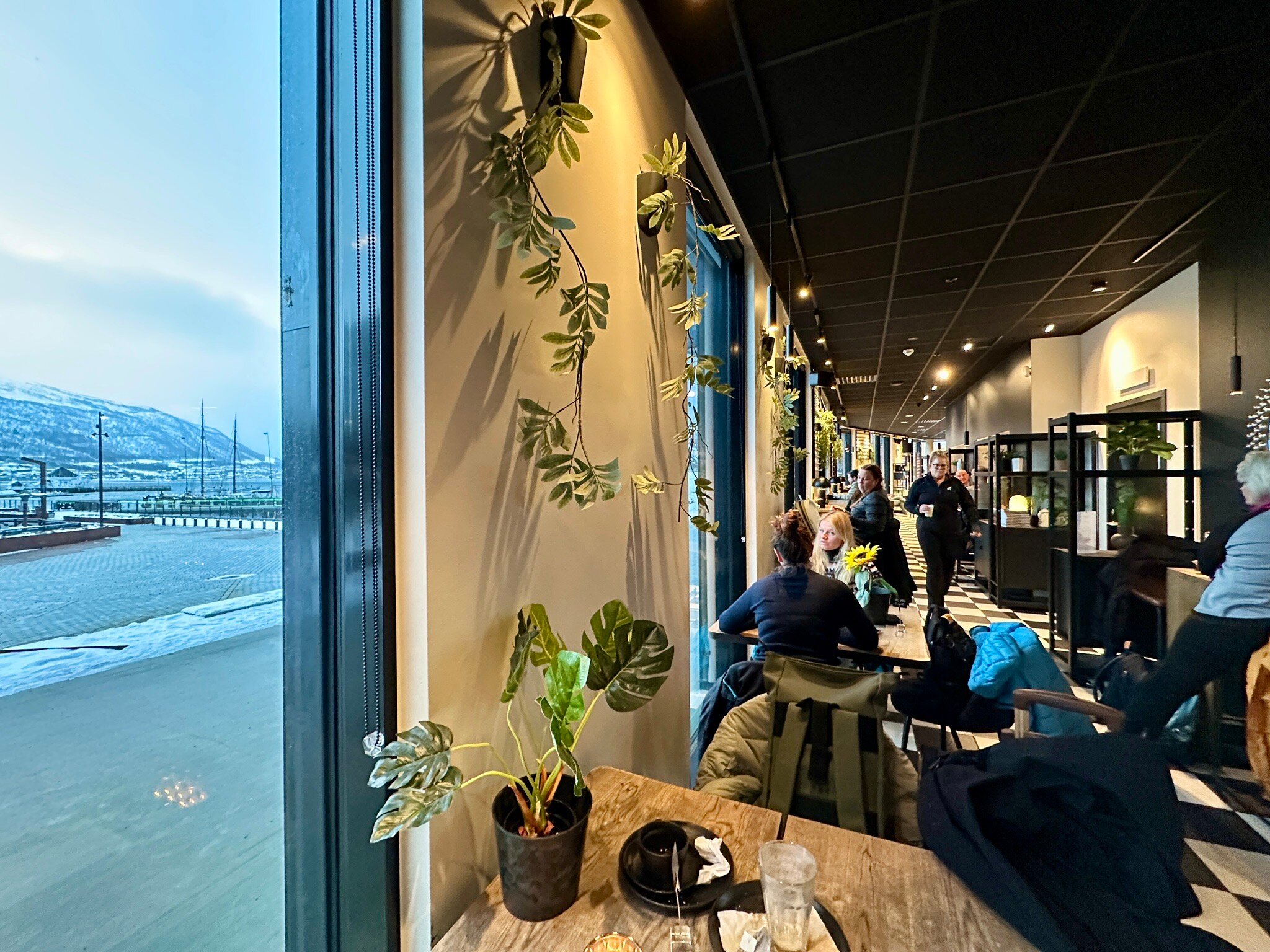 People sitting in a café overlooking Tromsø's snowy waterfront