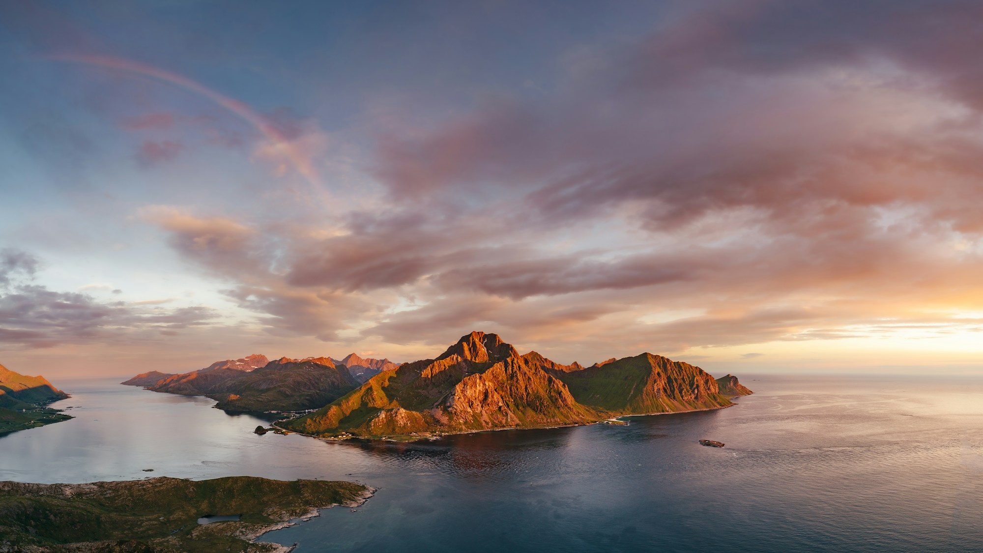 Golden midnight sun over a Norwegian island and sea