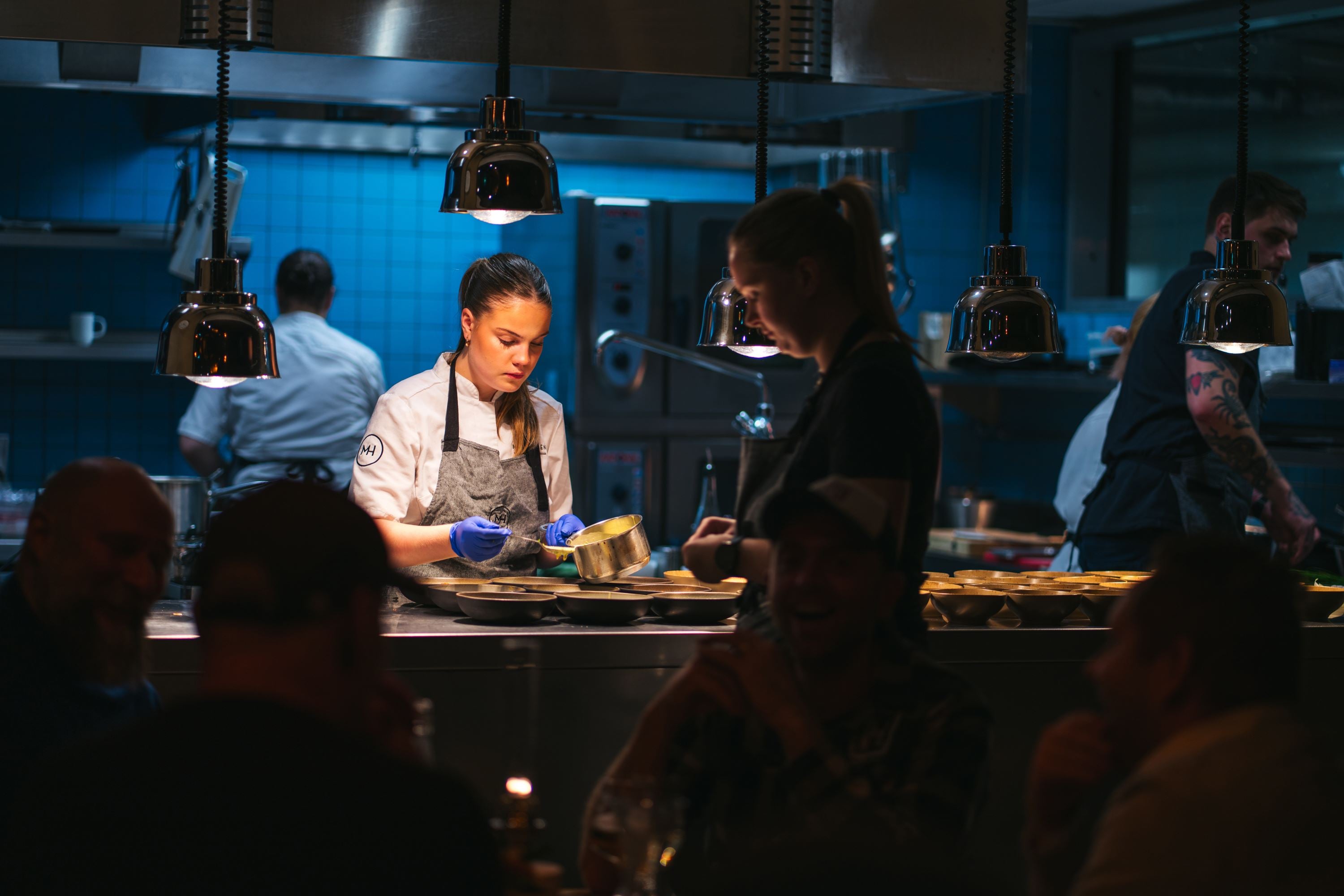 Chef plating dishes in the open kitchen at Mathallen Tromsø