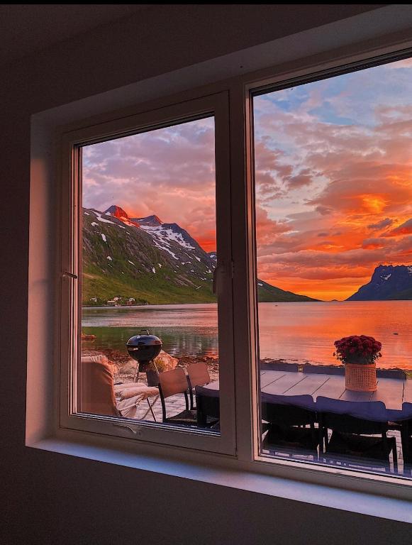 a window with a view of a sunset at House of Ellie in Ersfjordbotn — House of Ellie
