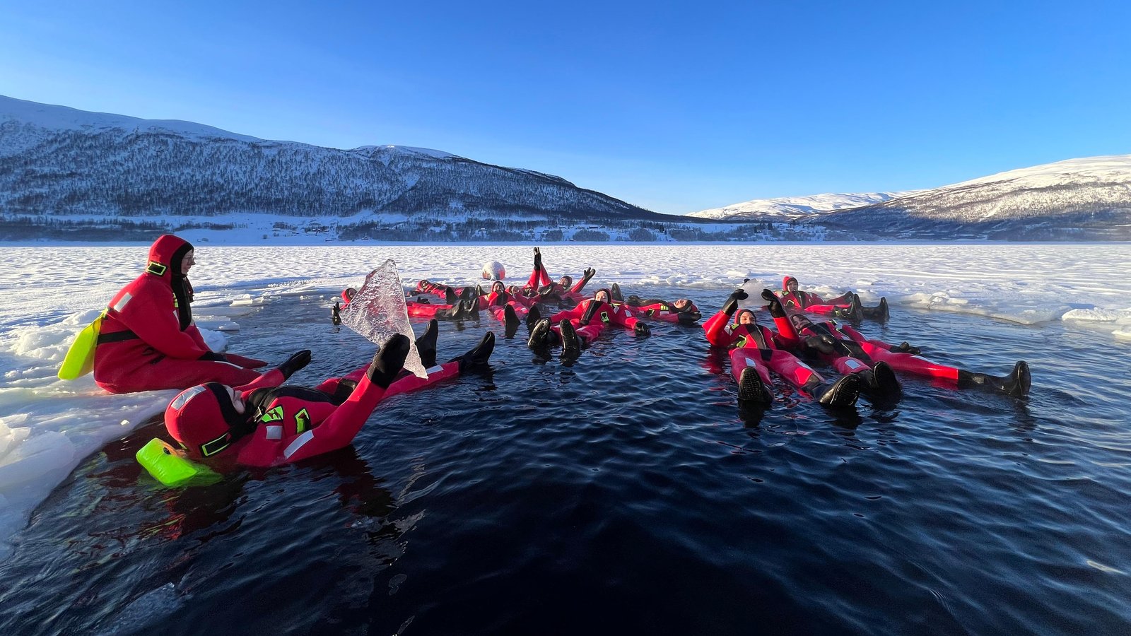 Guests floating in protective rescue suits in Arctic water