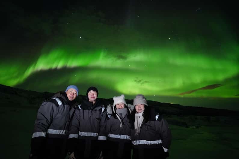 Faint aurora visible through a patchy cloudy sky