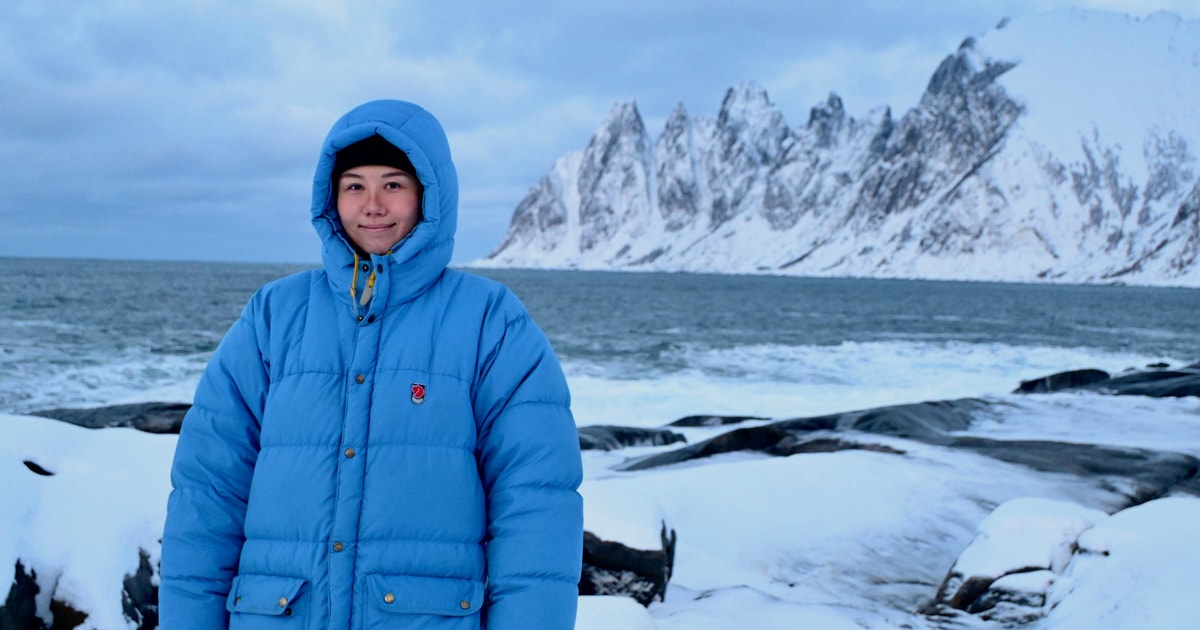 Traveller wearing an insulated hooded jacket on a snowy coastal stop