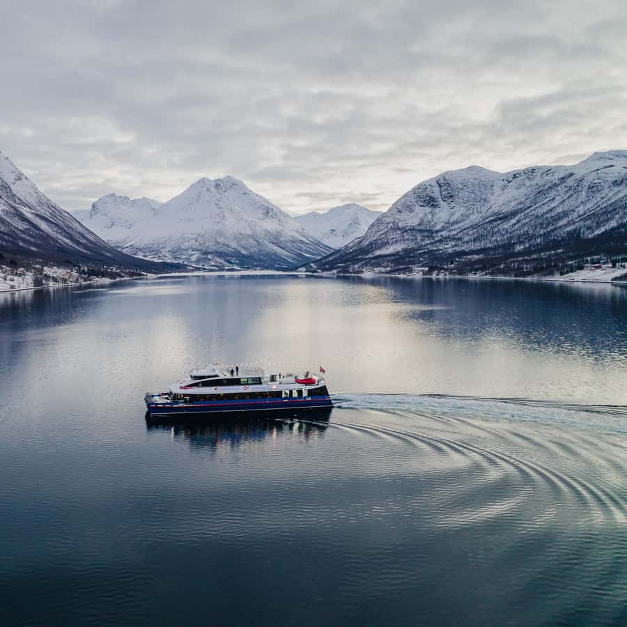 Rødne catamaran travelling through a snowy fjord near Tromsø — photo 1 of 4