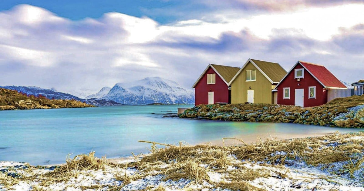 Colourful coastal houses, bare ground and snow-dusted mountains near Tromsø