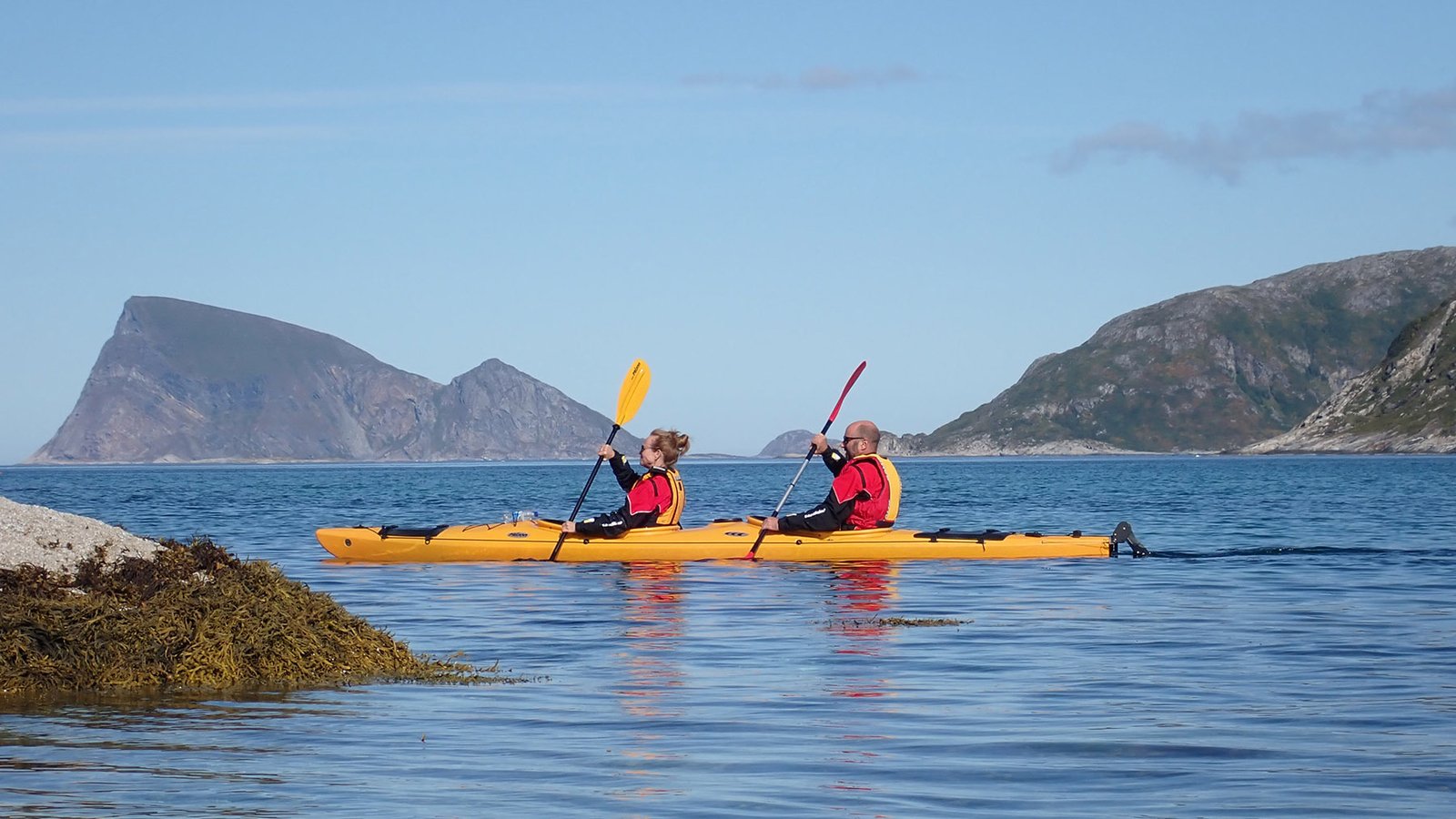 Sea kayakers paddling beside the Sommarøy coastline — photo 1 of 5