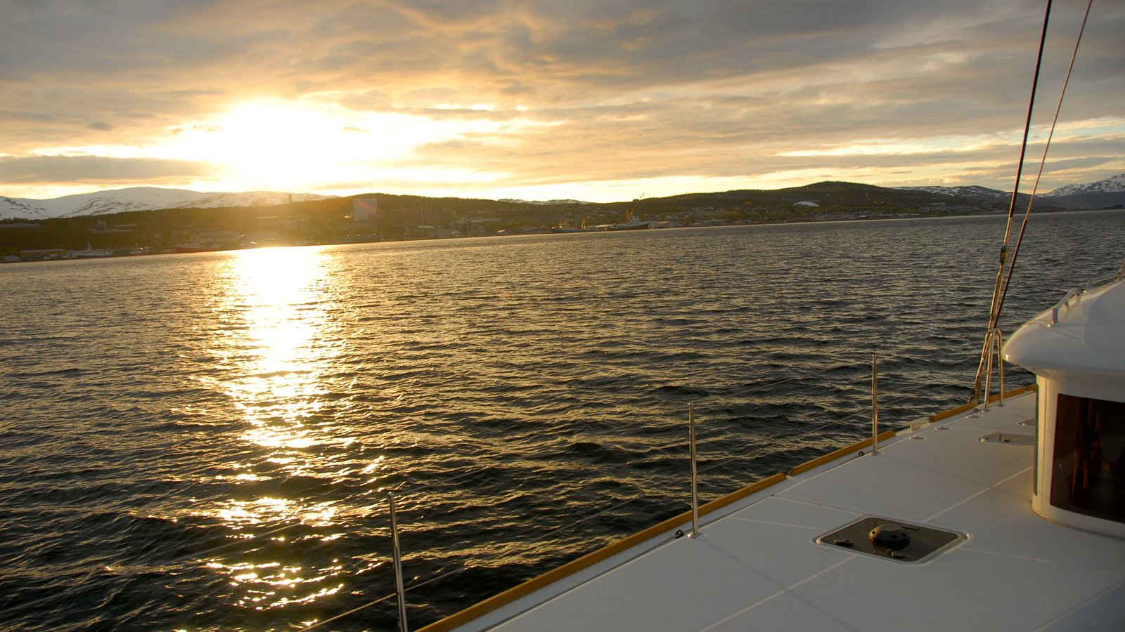 Catamaran sailing beneath the golden midnight sun near Tromsø — photo 1 of 5