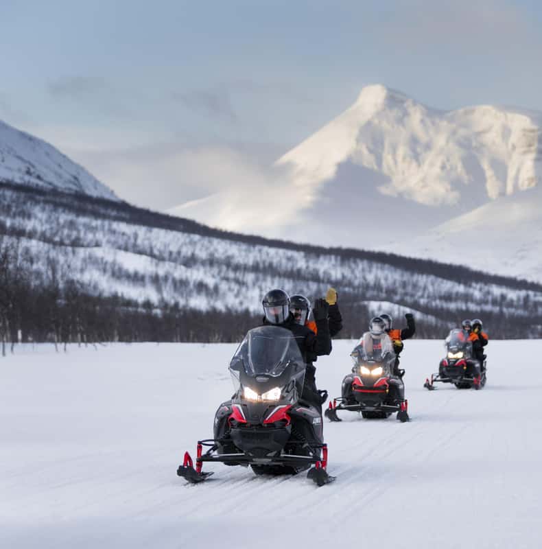 Snowmobile rider crossing the snowy Camp Tamok landscape at sunset — photo 1 of 5